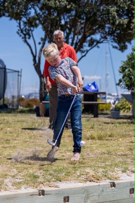 Harvey mid-swing playing golf
